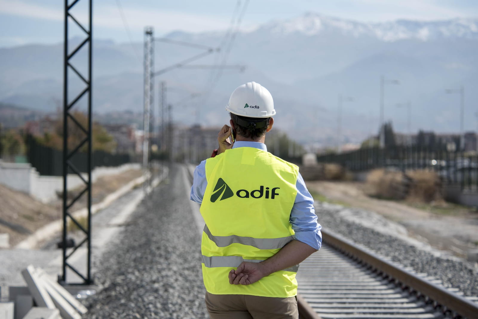 Trabajador ADIF supervisando la vía desde el margen de la infraestructura ferroviaria